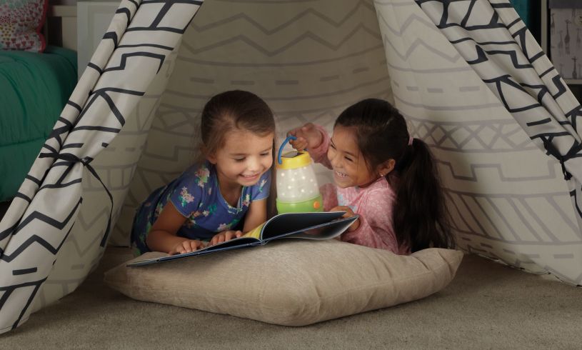 two young girls camping indoors with the solar lantern