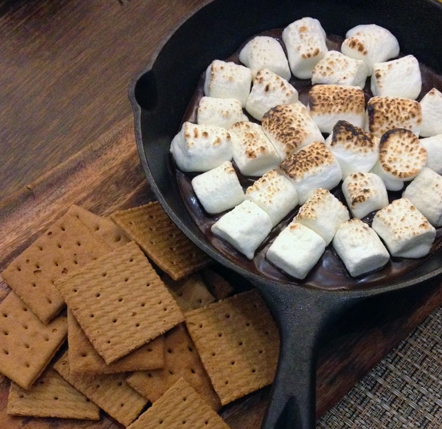toasted marshmallows in a frying pan, with plain biscuits on the side