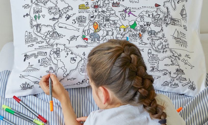 young girl drawing on the world map pillowcase