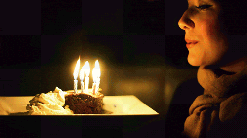 someone watching their birthday candles flicker