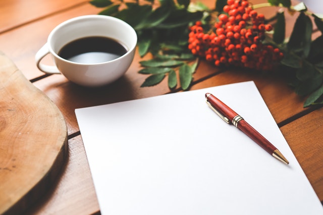 pen, paper, and a coffee