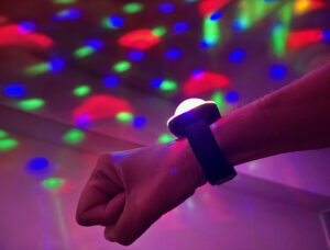 Person wearing Disco Ball Wristband and casting light pattern on the ceiling