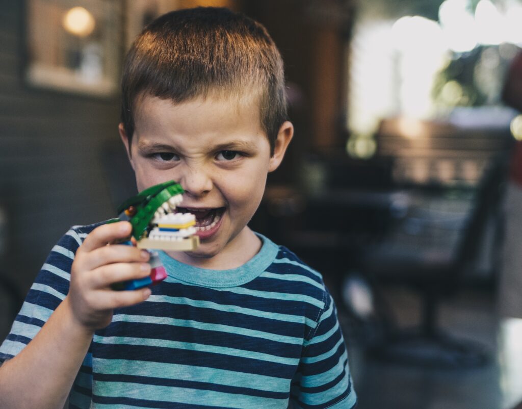 Young boy playing with monster toy