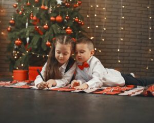 Two kids writing Christmas quiz