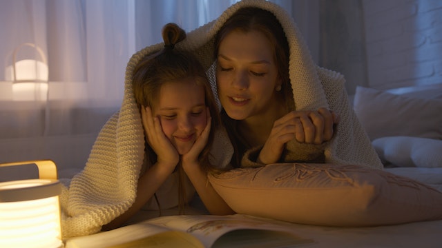 Kids night light with mum and daughter reading