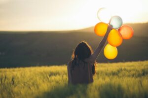 Woman in field with balloons