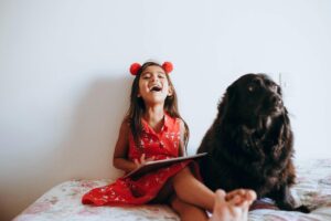 Happy girl sitting beside black dog